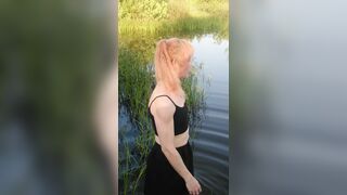 Transgirl swimming in clothes in lake wearing all black: pantyhose, skirt and top. Wetlook in lake.