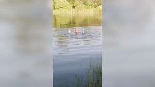 Transgirl swimming in clothes in lake wearing all black: pantyhose, skirt and top. Wetlook in lake.