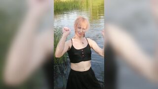 Transgirl swimming in clothes in lake wearing all black: pantyhose, skirt and top. Wetlook in lake.