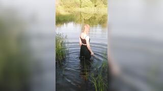 Transgirl swimming in clothes in lake wearing all black: pantyhose, skirt and top. Wetlook in lake.