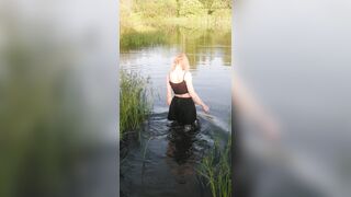 Transgirl swimming in clothes in lake wearing all black: pantyhose, skirt and top. Wetlook in lake.