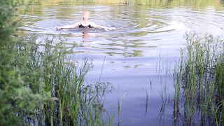 Swimming in lake in clothes. Black Wet skirt, wet stockings and tank top. Wetlook transgirl in lake.