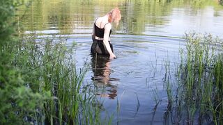 Swimming in lake in clothes. Black Wet skirt, wet stockings and tank top. Wetlook transgirl in lake.